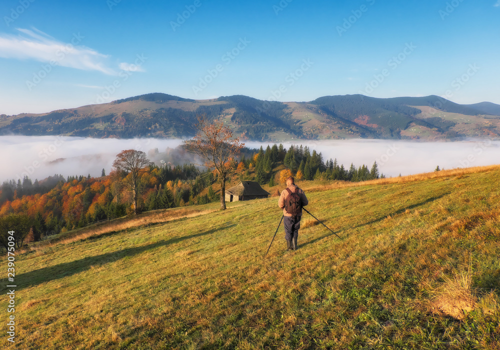 tourist in the mountains. photographer takes a sunrise in the mountains tourist in the mountains. photographer takes a sunrise in the mountains