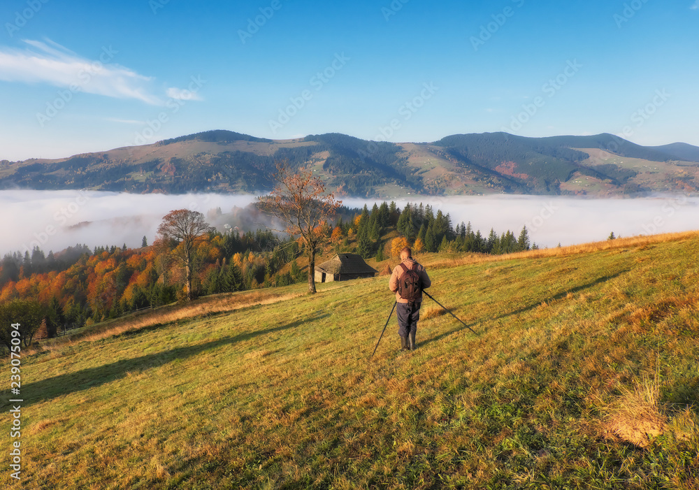 tourist in the mountains. photographer takes a sunrise in the mountains