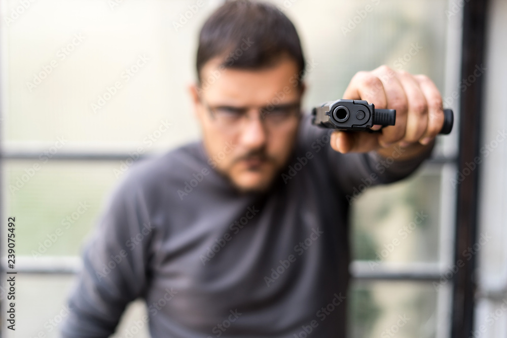man with gun pointed to the camera Stock Photo | Adobe Stock