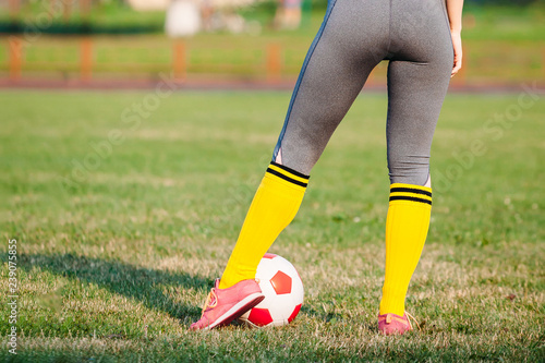 woman soccer player with ball on field