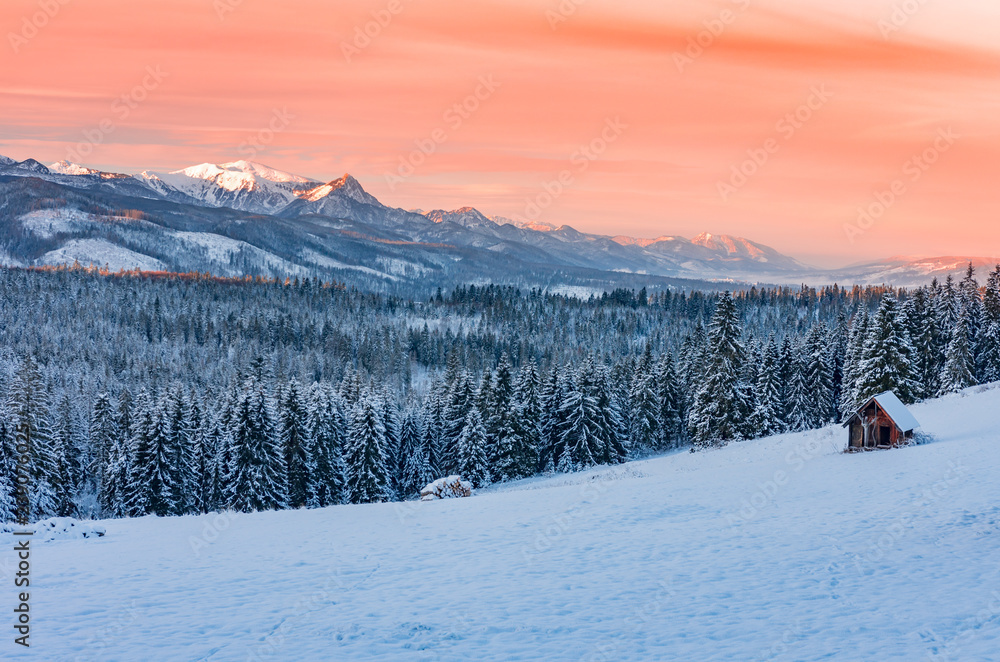 Winter Tatra mountains landscape with wooden hut at dawn