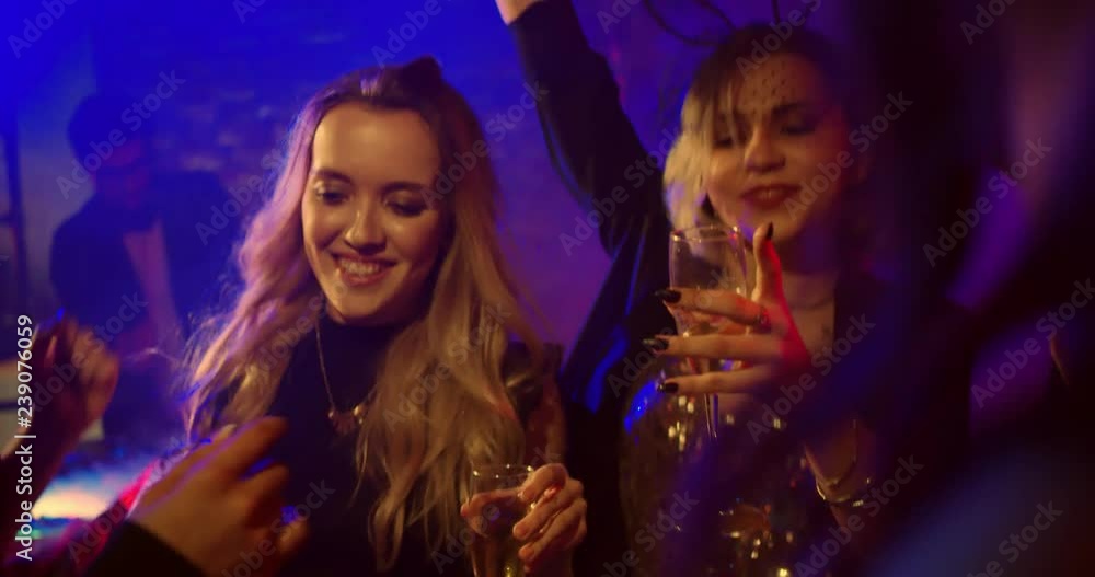 Girls Dancing with Glasses of Champagne/Girls Party in the nightclub. Girls are dancing, they hold glasses in their hands. Shot in Slow motion Girls Dancing with Glasses of Champagne/Girls Party in the nightclub. Girls are dancing, they hold glasses in their hands. Shot in Slow motion