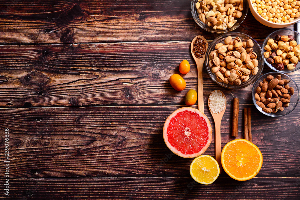 Copy space. Healthy food concept - citrus, avocado, apple, nuts, pomegranate, sliced. Wooden rustic table. Copy space. Healthy food concept - citrus, avocado, apple, nuts, pomegranate, sliced. Wooden rustic table.
