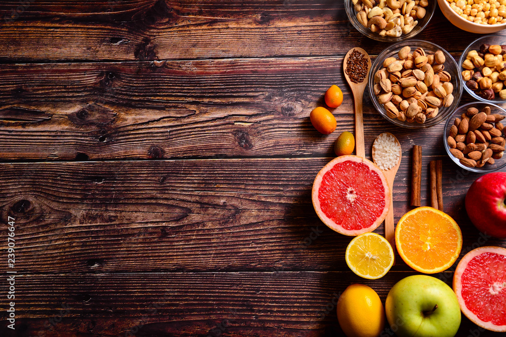 Copy space. Healthy food concept - citrus, avocado, apple, nuts, pomegranate, sliced. Wooden rustic table. Copy space. Healthy food concept - citrus, avocado, apple, nuts, pomegranate, sliced. Wooden rustic table.
