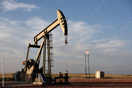 Crude oil pump jack and natural gas flare in the Powder River Basin of Wyoming, USA photo