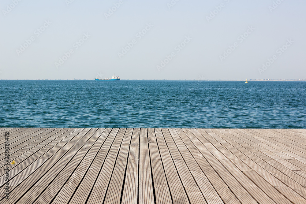 wooden deck waterfront sea shoreline background texture and water surface with small waves with horizon line, wallpaper pattern, copy space