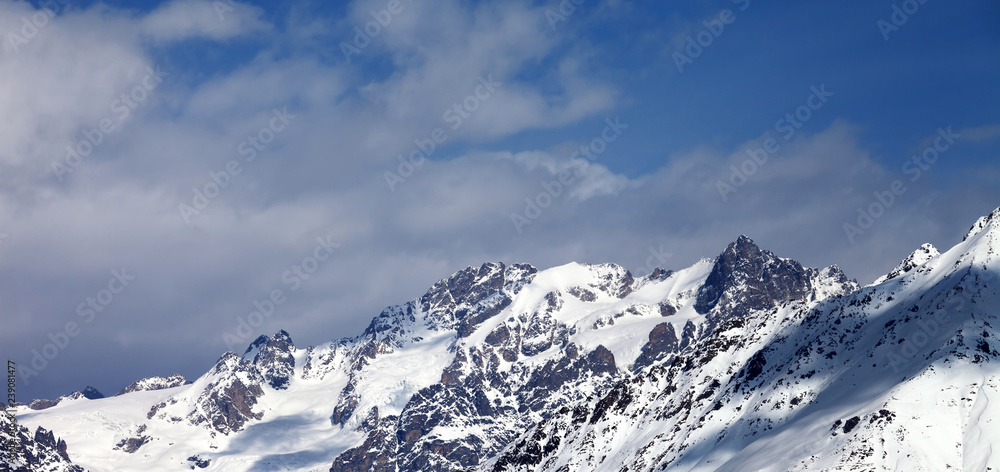 View on snowy mountains with glacier and cloudy blue sky View on snowy mountains with glacier and cloudy blue sky