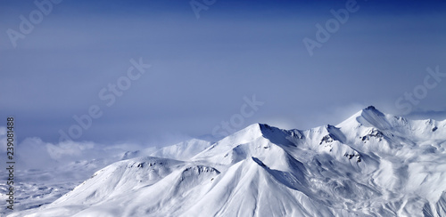 Panoramic view on snowy mountains in mist at winter evening © BSANI
