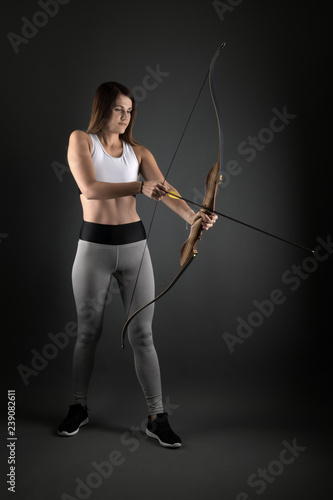 Young archer girl targeting with bow and arrow