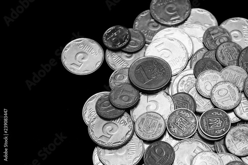 Ukrainian coins isolated on black background. Close-up view. Black and white image. Coins are located at the right side of frame. A conceptual image.