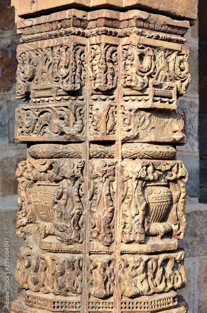 Column with intricate stone carving in courtyard of  Qutub complex, Delhi, India