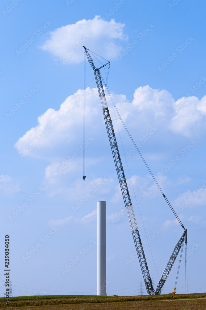Blue crane tower constructing windmill with background of blue sky. Wind Turbine Construction Blue crane tower constructing windmill with background of blue sky. Wind Turbine Construction