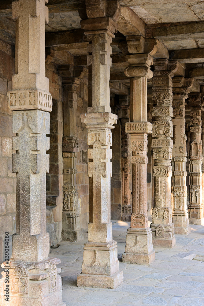 Columns with stone carving in courtyard of Quwwat Ul Islam mosque, Qutub Minaret complex, Delhi, India