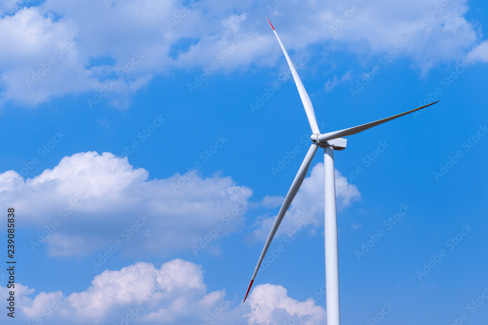 One single windmill turbine with partly cloudy blue sky in background. Renewable energy wind turbine One single windmill turbine with partly cloudy blue sky in background. Renewable energy wind turbine