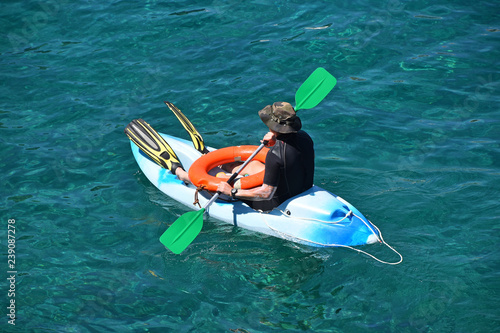 Beach lifeguard man at kayak boat in sea water © breakingthewalls