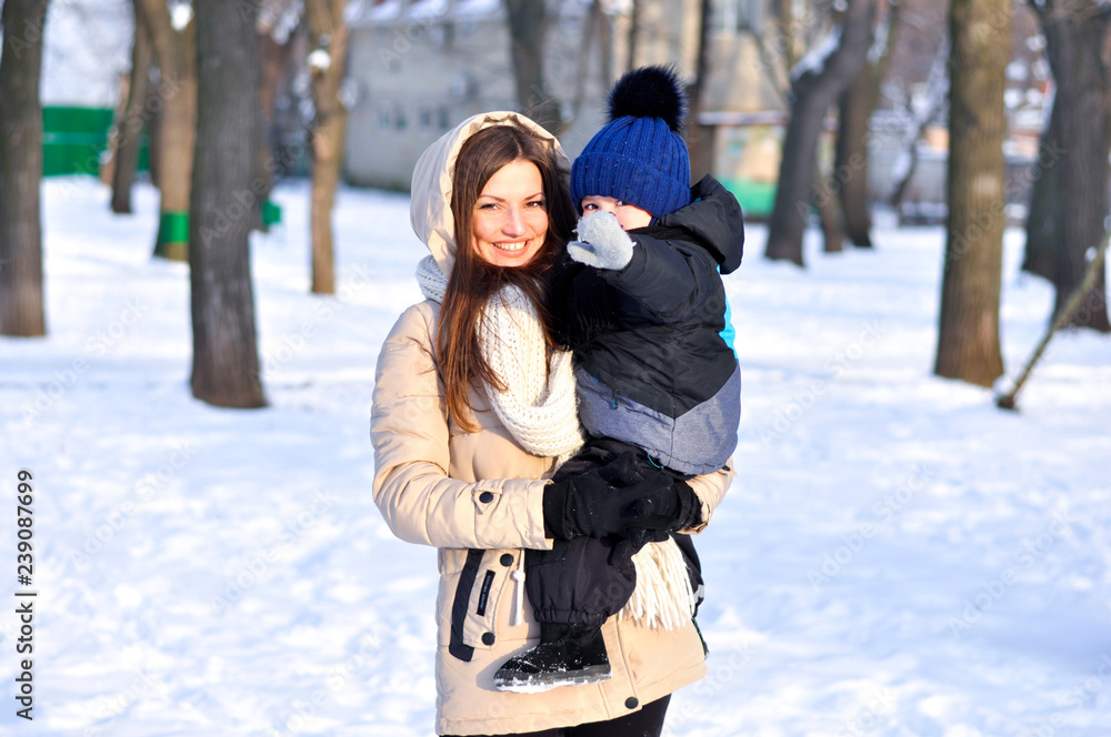 Young mother with a child for a walk in the winter park. Young mother with a child for a walk in the winter park.