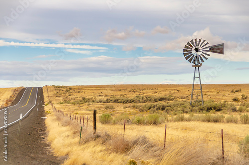 Old time windmill in Oregon field. Older outdated technology. Reminds of days gone by; lonely, days past..