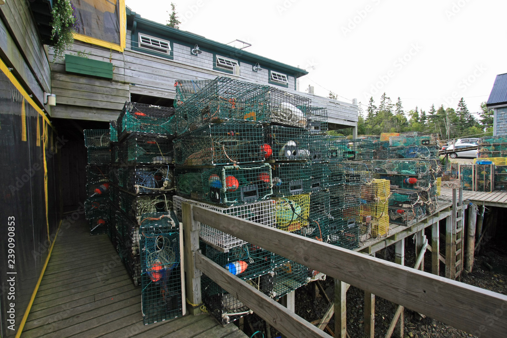Lobster traps and fishing equipment on the docks of Bass Harbor, Maine, on a sunny summer afternoon.