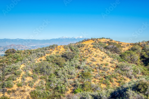 Hiking trails above urban area of Southern California with blue sky for text