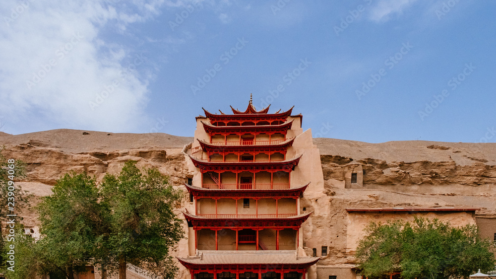 Nine-Level Building (Jiu Ceng Lou) against rocks under blue sky, at Mogao Caves in Dunhuang, Gansu, China Nine-Level Building (Jiu Ceng Lou) against rocks under blue sky, at Mogao Caves in Dunhuang, Gansu, China