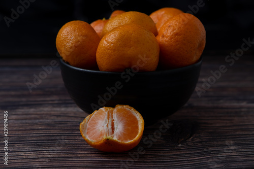 Oranges on the wood table on black background.