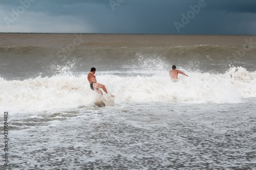 Men bathe in the sea during a storm © Vera