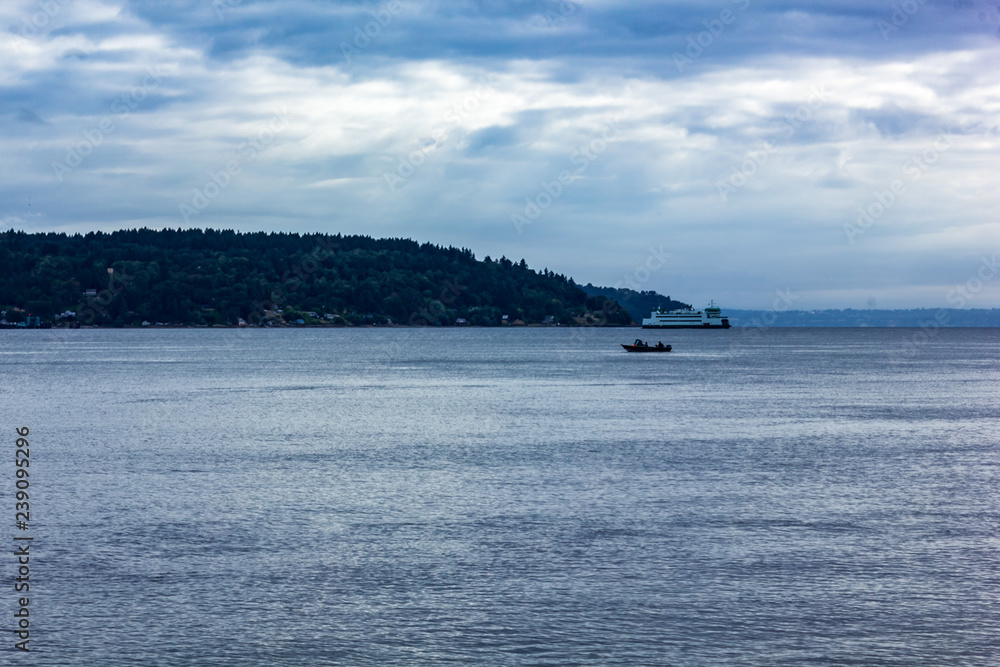 early morning ferry alongpuget sound with small speed boat early morning ferry alongpuget sound with small speed boat