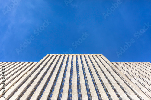 Brutalist skyscraper with blue skies looking up
