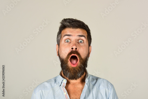 Astonished man with long beard&mustache. Fashionable bearded male portrait. Surprised bearded man in casual clothes. Fashion model with stylish hair. Hipster in white shirt. Barber fashion and beauty.