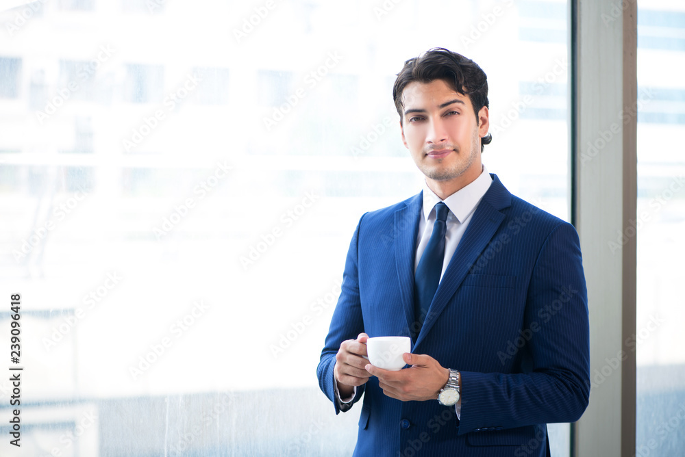 Young handsome businessman standing at the window Young handsome businessman standing at the window