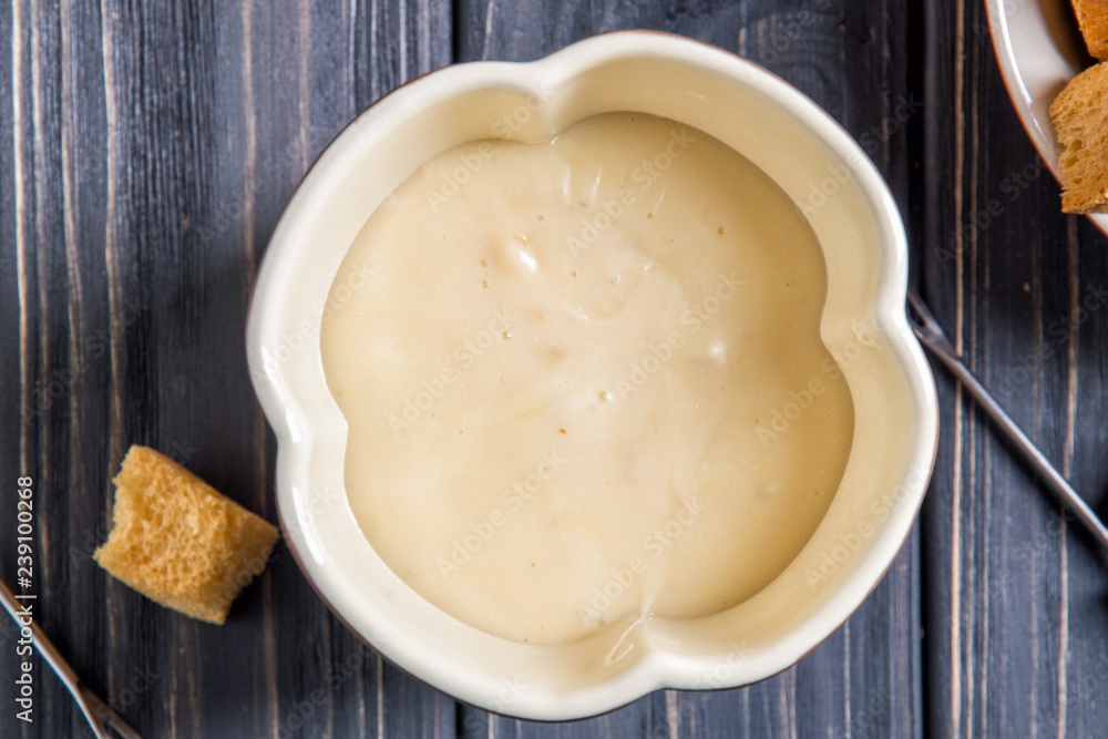 Flat lay. Traditional Swiss cheese fondue. Fondue pot with melted hot cheese. Flat lay. Traditional Swiss cheese fondue. Fondue pot with melted hot cheese.