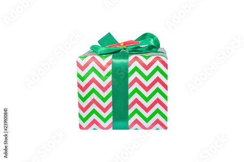 A box sealed with beautiful paper in green-red-white tones and tied with a green ribbon on an isolated white background, side view