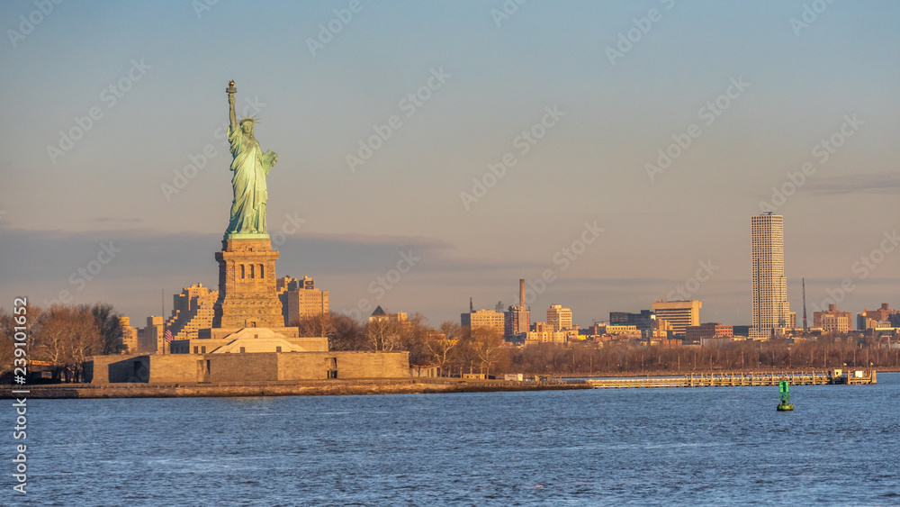 Statue of Liberty During Sunrise with New Jersey City in the background