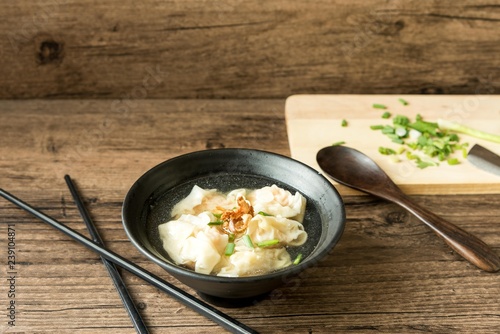 Shrimp wonton with braised pork in soup on wooden table - Asian food style    Select focus image