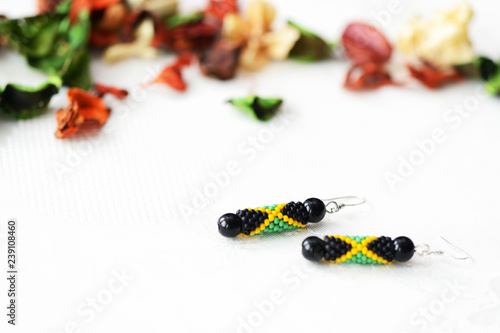 Handmade beaded earrings in style of jamaican flag close up