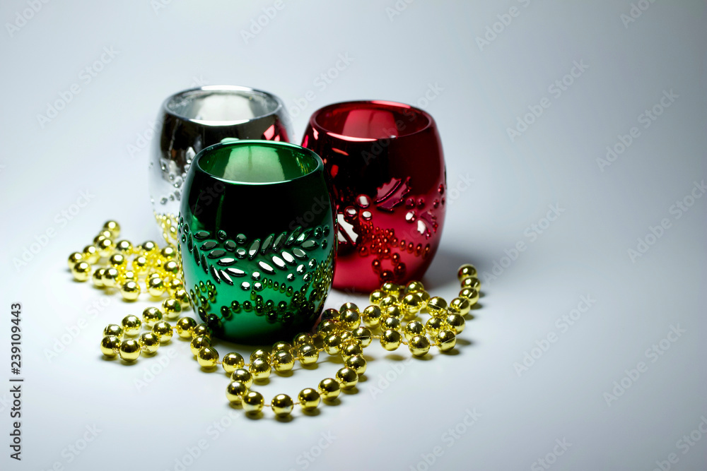 Obraz premium Macro abstract Christmas holiday decoration with three colorful metallic candle holders surrounded with shiny beads