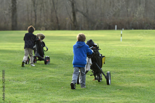Schilderij op canvas junior golfers pushing carts