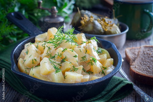young potatoes cooked in sour cream in a cast iron pan, horizontal