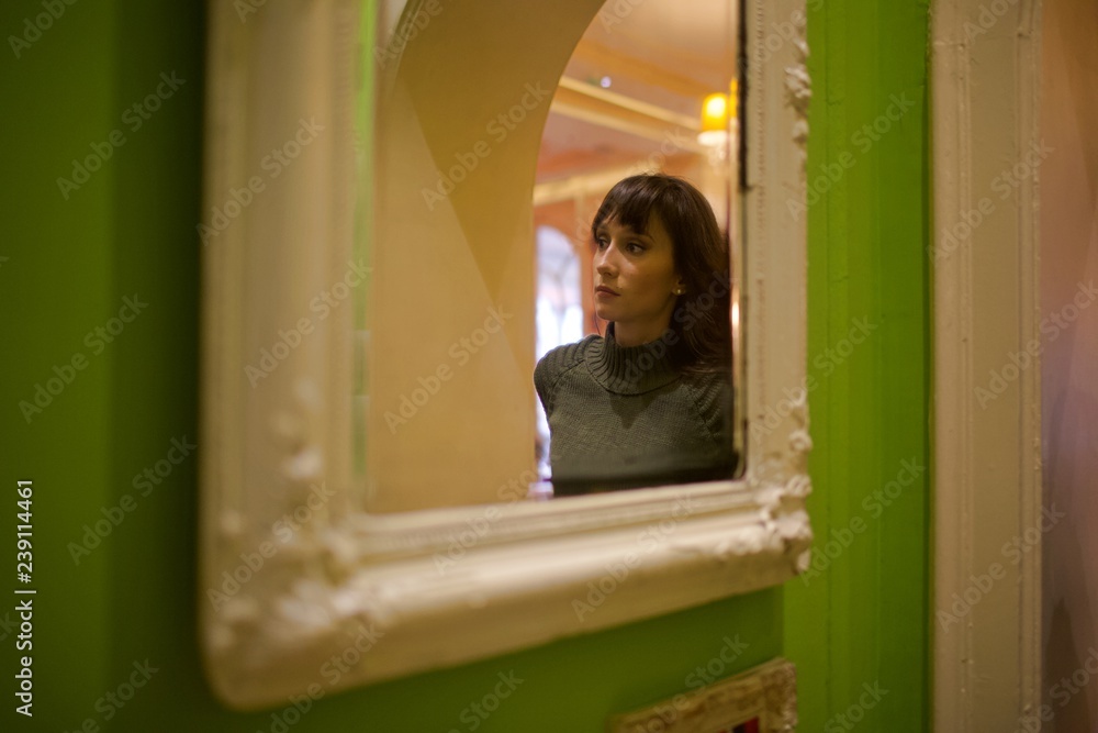 portrait of young brunette woman in home with flowers and mirror portrait of young brunette woman in home with flowers and mirror