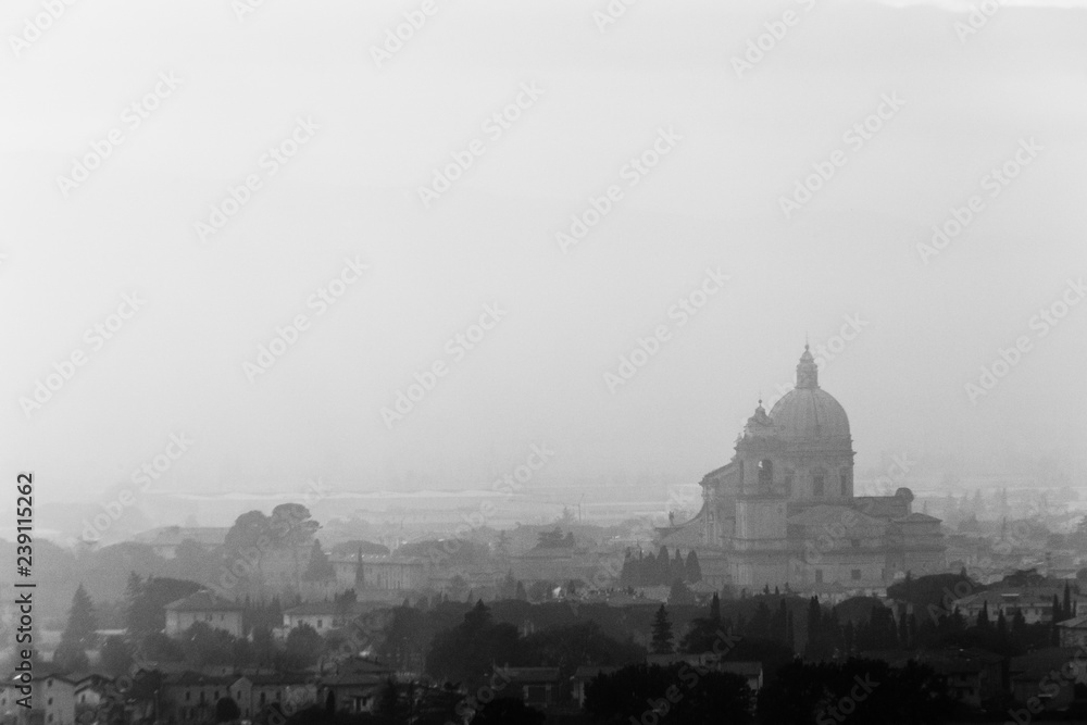 Moody view of S.M. degli Angeli church (Assisi, Umbria, Italy) in the midst of autumn mist