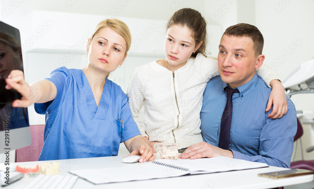 Fototapeta premium Female dentist explaining X-ray to patients