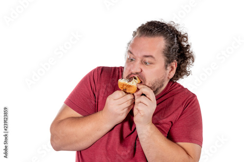 Funny fat man eating small croissant on white background. Good morning and breakfast