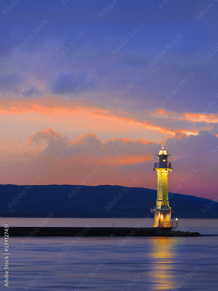 Antique lighthouse at multicolored dramatic sunset, Lake Geneva, Switzerland.