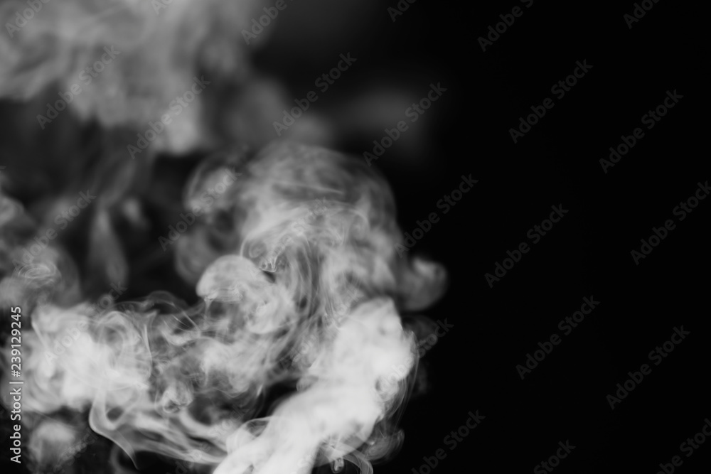 White smoke on a black background. Texture of smoke. Clubs of white smoke on a dark background for an overlay White smoke on a black background. Texture of smoke. Clubs of white smoke on a dark background for an overlay
