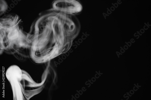 Fototapeta Naklejka Na Ścianę i Meble -  White smoke on a black background. Texture of smoke. Clubs of white smoke on a dark background for an overlay