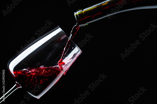 Red wine being poured into wineglass.