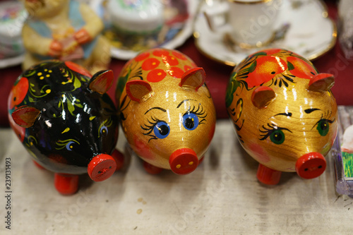 Khokhloma pigs at the table. Khokhloma is traditional wooden figurines panted in red, gold, black