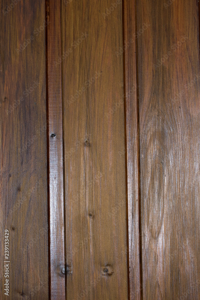 Fototapeta premium oberfläche einer bretterwand aus dunklem holz in hochformat mit maserungen fotografiert draußen im garten in niederlangen emsland deutschland