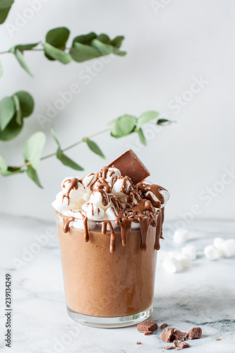 Chocolate mousse with marshmallows in a glass on a marble table photo