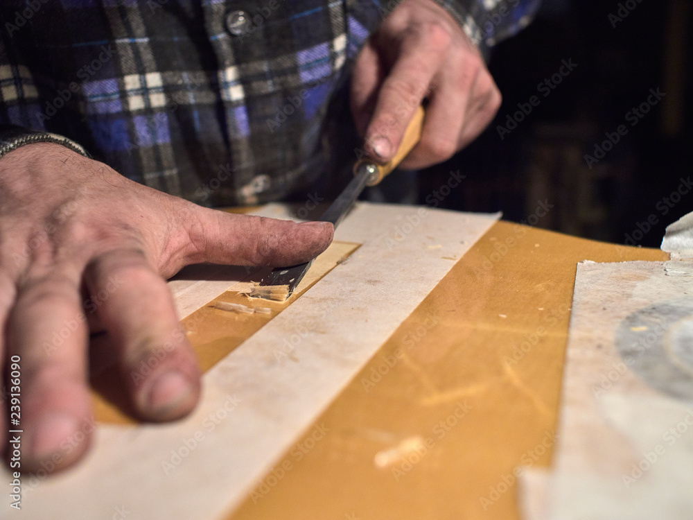 Installing a bridge on classical guitar body. The specialist removes varnish from the body of the guitar.